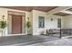Front entry with modern wood door, sidelights, and two potted plants at 360 N Point Rd, Osprey, FL 34229