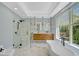 Elegant bathroom with soaking tub, double vanity, and marble floors at 360 N Point Rd, Osprey, FL 34229