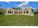 Back exterior view of the house with lawn and landscaping at 360 N Point Rd, Osprey, FL 34229