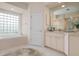 Bathroom features a soaking tub, double vanity, and a glass block window at 5249 Far Oak Cir, Sarasota, FL 34238
