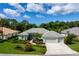 Single-story home with grey roof, attached garage, and landscaped yard at 5249 Far Oak Cir, Sarasota, FL 34238