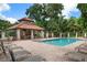 Community pool with a covered patio and lounge chairs at 5249 Far Oak Cir, Sarasota, FL 34238