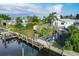 Aerial view of a home with a backyard deck, boat dock, a storage shed and lush greenery at 508 65Th St, Holmes Beach, FL 34217