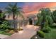 Luxury home exterior at sunset, featuring a tile roof and palm trees at 14215 Kinglet Ter, Lakewood Ranch, FL 34202