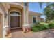 Elegant home entryway with double doors, arched entry, and manicured landscaping at 14215 Kinglet Ter, Lakewood Ranch, FL 34202