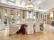 Sunlit dining room with a large table, chandelier, and access to the outdoors at 815 Tropical Cir, Sarasota, FL 34242