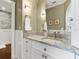 Modern bathroom with a white vanity, grey marble countertops, and a large mirror at 815 Tropical Cir, Sarasota, FL 34242