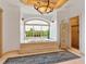 Spa-like bathroom with a large soaking tub, elegant chandelier and big window at 815 Tropical Cir, Sarasota, FL 34242