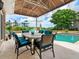 Outdoor dining area with pool view, covered patio, and comfortable seating at 815 Tropical Cir, Sarasota, FL 34242