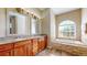 Elegant bathroom featuring double sinks and a soaking tub at 17706 Bridlewood Ct, Parrish, FL 34219