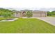 Tan house with three-car garage, palm trees, and a well-manicured lawn at 17706 Bridlewood Ct, Parrish, FL 34219