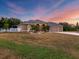 House exterior at dusk featuring a two-car garage and manicured lawn at 17706 Bridlewood Ct, Parrish, FL 34219