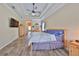 Serene main bedroom with hardwood floors, tray ceiling, and an en-suite bathroom creating a relaxing retreat at 17706 Bridlewood Ct, Parrish, FL 34219