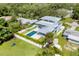 Stunning aerial view of a modern home featuring a backyard swimming pool, a well-manicured lawn, and lush landscaping at 2234 Hibiscus St, Sarasota, FL 34239