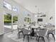 Bright dining area featuring stylish chairs, modern lighting, and large windows showcasing the backyard and swimming pool at 2234 Hibiscus St, Sarasota, FL 34239