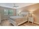 Cozy bedroom features a ceiling fan and large window with backyard views at 7673 Fairway Woods Dr # 706, Sarasota, FL 34238