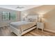 Cozy bedroom with a ceiling fan and large window providing natural light at 7673 Fairway Woods Dr # 706, Sarasota, FL 34238
