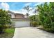 Exterior of home with a two-car garage and well-manicured landscaping at 7673 Fairway Woods Dr # 706, Sarasota, FL 34238