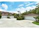 Detached garages are surrounded by mature landscaping under sunny skies at 7673 Fairway Woods Dr # 706, Sarasota, FL 34238