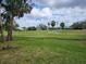 Spacious backyard view featuring a pristine golf course, mature trees, and clear skies at 7673 Fairway Woods Dr # 706, Sarasota, FL 34238