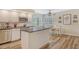 Kitchen area with a central island, stainless steel appliances, and a breakfast nook with natural light at 7673 Fairway Woods Dr # 706, Sarasota, FL 34238