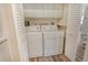 Bright laundry room featuring a washer, dryer, cabinets, and folding doors at 7673 Fairway Woods Dr # 706, Sarasota, FL 34238