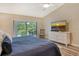 Spacious main bedroom features a king bed, an ensuite bath, and balcony access with natural views at 7673 Fairway Woods Dr # 706, Sarasota, FL 34238