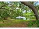 Mature trees frame a pond with a fountain, creating a tranquil scene at 7673 Fairway Woods Dr # 706, Sarasota, FL 34238