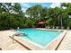 Community pool with crystal-clear water, a covered seating area, and ample lounge chairs for relaxing under the sun at 7673 Fairway Woods Dr # 706, Sarasota, FL 34238