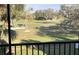 Screened in patio offers serene views of a lush golf course with mature trees at 7673 Fairway Woods Dr # 706, Sarasota, FL 34238