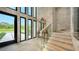 Bright entryway with glass staircase, ornate mirror, and stone wall at 2945 Pyrula Dr, Longboat Key, FL 34228