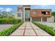 Modern home with brick and wood exterior, double garage, and landscaped walkway at 2945 Pyrula Dr, Longboat Key, FL 34228