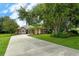 Driveway view showing a home with mature trees and landscaping at 815 128Th Ne St, Bradenton, FL 34212