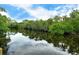 Peaceful canal view with reflecting trees and sky at 815 128Th Ne St, Bradenton, FL 34212