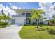 Modern two-story home with gray exterior, palm trees, and a spacious driveway at 2234 Hibiscus St, Sarasota, FL 34239