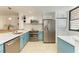 Modern kitchen with teal cabinets, stainless steel appliances, and quartz countertops at 184 Pineneedle Dr # 184, Bradenton, FL 34210