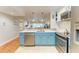 Updated kitchen boasting teal cabinets, stainless steel appliances, and a breakfast bar at 184 Pineneedle Dr # 184, Bradenton, FL 34210