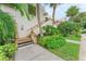 Condo building exterior featuring a wooden staircase and green landscaping at 184 Pineneedle Dr # 184, Bradenton, FL 34210