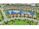 Aerial view of a residential area featuring houses with manicured lawns lining a lake, offering a serene living environment at 13215 Ramblewood Trl, Bradenton, FL 34211