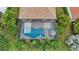Aerial view of the screened-in pool and hot tub with lush landscaping providing privacy and relaxation at 13215 Ramblewood Trl, Bradenton, FL 34211