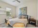 Bright bedroom with a ceiling fan, large window, neutral tones, and a comfortable seating area at 13215 Ramblewood Trl, Bradenton, FL 34211
