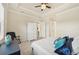 Cozy bedroom with neutral walls, tray ceiling, chair, ceiling fan and ample storage space at 13215 Ramblewood Trl, Bradenton, FL 34211
