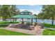 Picturesque gazebo with picnic tables overlooking a tranquil lake, perfect for outdoor gatherings at 13215 Ramblewood Trl, Bradenton, FL 34211
