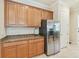 Kitchen area with stainless steel refrigerator, granite counters and wood cabinets at 13215 Ramblewood Trl, Bradenton, FL 34211
