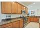 Kitchen features wood cabinets, granite countertops, stainless steel appliances, and recessed lighting at 13215 Ramblewood Trl, Bradenton, FL 34211