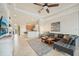 Open-concept living room features tile floors, a tray ceiling, neutral décor, and seamless flow to the kitchen at 13215 Ramblewood Trl, Bradenton, FL 34211