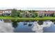 Serene water view of the rear exterior featuring a screened pool and lush landscaping creating a private retreat at 13215 Ramblewood Trl, Bradenton, FL 34211