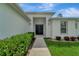 Home's front entrance with walkway and lush landscaping at 1174 S Mcduff St, North Port, FL 34288