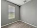 Bright bedroom with window blinds, gray walls, and wood-look flooring at 1174 S Mcduff St, North Port, FL 34288
