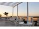 Relaxing patio with white furniture and pergola overlooking scenic landscape at 7275 Lismore Ct, Lakewood Ranch, FL 34202